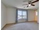 Well-lit bedroom with neutral carpet, a ceiling fan and a large window at 6442 Kobe Knoll Ct, Las Vegas, NV 89141