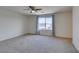 Large bedroom with a window, ceiling fan, neutral carpet and gray curtains at 6442 Kobe Knoll Ct, Las Vegas, NV 89141