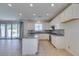Open kitchen with white cabinets, an island, and stainless steel appliances overlooking living area at 6442 Kobe Knoll Ct, Las Vegas, NV 89141