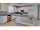 Modern kitchen with stainless steel appliances, island, white cabinets, and gray countertops at 6442 Kobe Knoll Ct, Las Vegas, NV 89141
