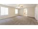 Light-filled bedroom features neutral carpeting, ceiling fan, and archway to Primary bath at 6591 Gertrude Ct, Las Vegas, NV 89141