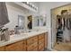 Bathroom featuring double sinks, wood cabinets and an adjacent closet at 7616 Yondering Ave, Las Vegas, NV 89131