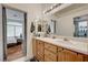 Bathroom featuring double sinks, light wood cabinets and an adjoining bedroom at 7616 Yondering Ave, Las Vegas, NV 89131