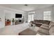 Open-concept living area with tile floors, a large sectional sofa, and a view of the backyard, ideal for relaxation at 7616 Yondering Ave, Las Vegas, NV 89131