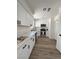 Well-lit kitchen with stainless steel appliances, white cabinets, and laminate flooring at 8068 Cetus Cir, Las Vegas, NV 89128