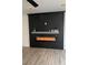 Living room features a black accent wall with modern electric fireplace and wood-look flooring at 8068 Cetus Cir, Las Vegas, NV 89128