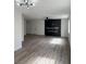 Open living room with wood-look floors, modern lighting and fireplace accent wall at 8068 Cetus Cir, Las Vegas, NV 89128