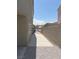 Narrow side yard with gate, concrete walkway, and low-maintenance gravel landscaping on a sunny day at 8068 Cetus Cir, Las Vegas, NV 89128