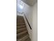 Staircase featuring wood steps, a black handrail, and bright natural light at 8068 Cetus Cir, Las Vegas, NV 89128