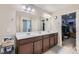 Elegant bathroom featuring dual sinks, dark wood cabinetry, and a large mirror, enhancing the space at 8295 Nebula Cloud Ave, Las Vegas, NV 89131