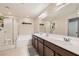 Well-lit bathroom featuring double sinks, modern fixtures, and a separate shower, offering convenience and style at 8295 Nebula Cloud Ave, Las Vegas, NV 89131