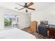 Bright bedroom featuring wood-look floors, a ceiling fan, and a large window at 8341 Lower Trailhead Ave, Las Vegas, NV 89113