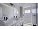 Bathroom featuring a dual sink vanity and a walk in shower with white marble tile at 836 Cherry Dr, Henderson, NV 89002