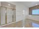 A bright bathroom with a glass enclosed shower, marble floor and a bathtub at 905 Star Pine Dr, Las Vegas, NV 89144