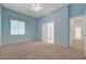 A light blue bedroom with carpet, ceiling fan and a view to a corridor at 905 Star Pine Dr, Las Vegas, NV 89144