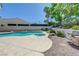 Backyard with a sparkling pool and hot tub, lush greenery, and a built-in grill area for easy outdoor entertaining at 905 Star Pine Dr, Las Vegas, NV 89144