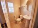 Powder room with pedestal sink, a standard toilet, and a window for natural lighting at 9069 Tantalizing Ave, Las Vegas, NV 89149