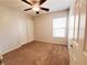 Cozy bedroom with plush carpet, a ceiling fan, natural light, and a closet with sliding doors at 9069 Tantalizing Ave, Las Vegas, NV 89149