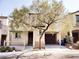 Two-story home featuring a tree in the front yard, a dark brown garage door, and neutral colored walls at 9069 Tantalizing Ave, Las Vegas, NV 89149