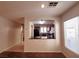View of a living room with an archway leading to a kitchen with dark cabinets and countertops at 9069 Tantalizing Ave, Las Vegas, NV 89149