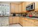 A well-lit kitchen with light wood cabinets and stainless steel microwave at 9660 Drayton Ave, Las Vegas, NV 89148