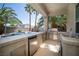 Outdoor kitchen with stainless steel appliances and tile countertops near the pool at 9660 Drayton Ave, Las Vegas, NV 89148