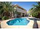 Inviting backyard oasis with a sparkling pool, spa, and lush palm trees, perfect for outdoor relaxation and entertainment at 9660 Drayton Ave, Las Vegas, NV 89148