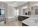 Bright bathroom features a soaking tub, double vanity and tile flooring at 9950 Coyote Echo Ct, Las Vegas, NV 89166