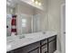 Bathroom featuring a large mirror over double sinks with chrome faucets at 9950 Coyote Echo Ct, Las Vegas, NV 89166