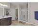 This bathroom showcases a glass-enclosed shower, dark cabinetry and neutral tile flooring at 9950 Coyote Echo Ct, Las Vegas, NV 89166
