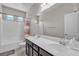 Bright bathroom boasting double sinks, a shower-tub combo, and modern fixtures at 9950 Coyote Echo Ct, Las Vegas, NV 89166