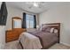 Bedroom includes a bed, a wooden dresser, a ceiling fan, and natural light from the window at 9950 Coyote Echo Ct, Las Vegas, NV 89166