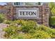 Stone community sign for Teton with beautiful landscaping and flowering shrubs at 9950 Coyote Echo Ct, Las Vegas, NV 89166
