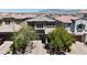 Two story home showcasing the facade, mature landscaping, a brick driveway, and two car garage at 9950 Coyote Echo Ct, Las Vegas, NV 89166