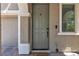 Inviting front door with sidelight and matching hardware, set in stucco exterior with brick pavers and column at 9950 Coyote Echo Ct, Las Vegas, NV 89166