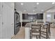 Contemporary kitchen with stainless appliances, dark cabinets, tile backsplash, a granite island, and bar seating at 9950 Coyote Echo Ct, Las Vegas, NV 89166