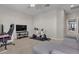 This living room has a gray sectional sofa and an exercise bike, next to a home office setup at 9950 Coyote Echo Ct, Las Vegas, NV 89166