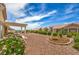 Landscaped backyard featuring a pergola, mature trees, and bushes with desert landscaping at 10421 Linfield Pl, Las Vegas, NV 89134