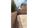 View of the backyard featuring a concrete patio, gravel area, retaining wall and the side of the house at 1081 Overture Dr, Las Vegas, NV 89123