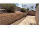 Landscaped backyard featuring a concrete patio, gravel area, cinder block retaining wall and mature bushes at 1081 Overture Dr, Las Vegas, NV 89123