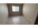 A bedroom with neutral paint and tile flooring, with a view to the exterior at 1081 Overture Dr, Las Vegas, NV 89123