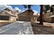 Home exterior featuring a spacious driveway, a lawn, tree and front yard landscaping at 1081 Overture Dr, Las Vegas, NV 89123