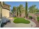 Beautiful backyard with well-manicured artificial turf, complemented by lush greenery and string lights at 11417 Rock Cove Way, Las Vegas, NV 89141