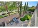 Charming backyard featuring patio with sitting area, a putting green, tall trees, and perimeter wall at 11417 Rock Cove Way, Las Vegas, NV 89141