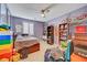 Bright bedroom featuring light wood floors, fan, and many shelves for storing collectibles at 11417 Rock Cove Way, Las Vegas, NV 89141