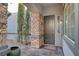 Covered front porch features stone accents, iron door, window with shutters and desert landscaping at 11417 Rock Cove Way, Las Vegas, NV 89141