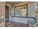 Covered front porch features stone accents, bench seating, iron door and window with shutters at 11417 Rock Cove Way, Las Vegas, NV 89141