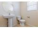 Powder room featuring a pedestal sink, toilet, and a neutral color palette at 11577 Vesuvio Ct, Las Vegas, NV 89183