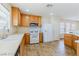 Well-lit kitchen with a gas range, white appliances, and wood cabinets at 11577 Vesuvio Ct, Las Vegas, NV 89183