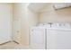 Bright laundry room with washer, dryer, wire shelves and closet at 11577 Vesuvio Ct, Las Vegas, NV 89183